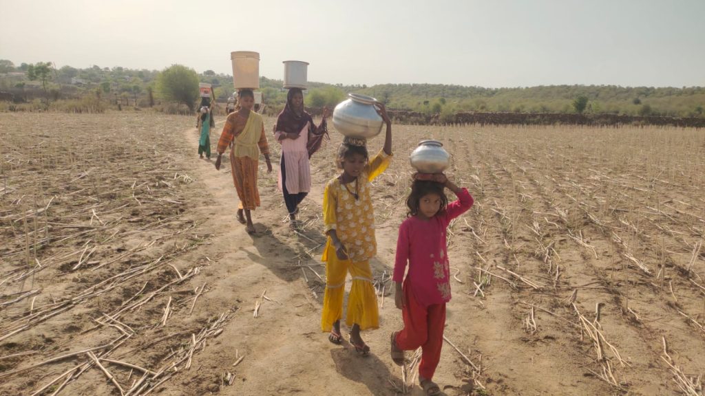 मुरैना का मानपुर: आदिवासी महिलाएं दो किलोमीटर दूर से पानी ढोती हुई दिखाई दे रही हैं